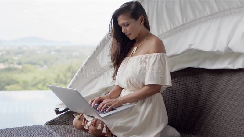 Relaxed woman using laptop on terrace against beautiful landscape