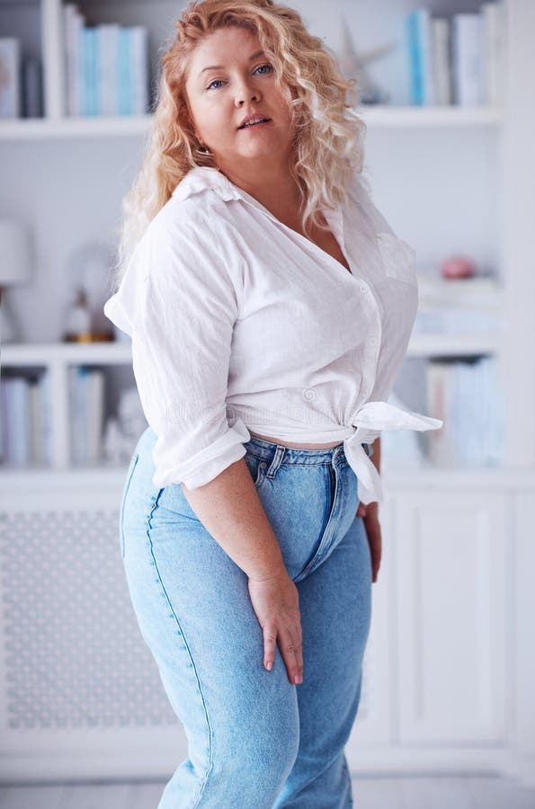 Attractive plus size woman wearing high waist jeans and knotted shirt
