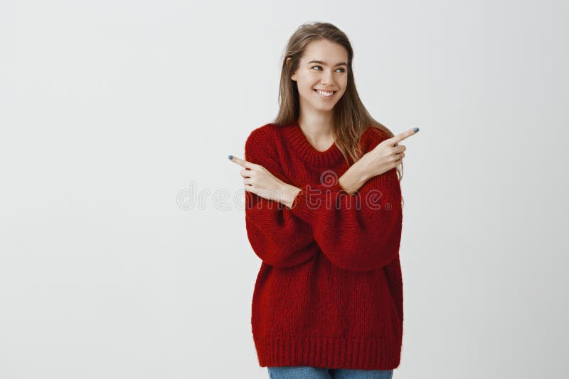 Attractive popular girl making decision on what date go. Pleased joyful caucasian woman in red loose trendy sweater royalty free stock photography Attractive popular girl making decision on what date go. Pleased joyful caucasian woman in red loose trendy sweater royalty free stock photography