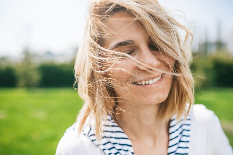 Attractive pretty female with blond blowing hair and closed eyes enjoy weather. Close up shot of Caucasian beautiful young woman royalty free stock photo Attractive pretty female with blond blowing hair and closed eyes enjoy weather. Close up shot of Caucasian beautiful young woman royalty free stock photo