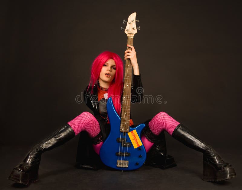 Attractive rock girl sitting with bass guitar