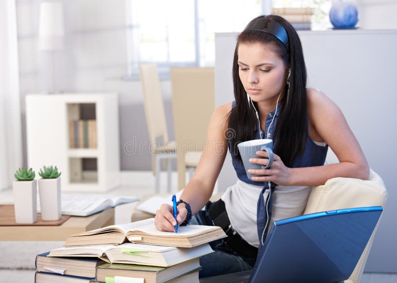 Attractive schoolgirl learning at home royalty free stock photography
