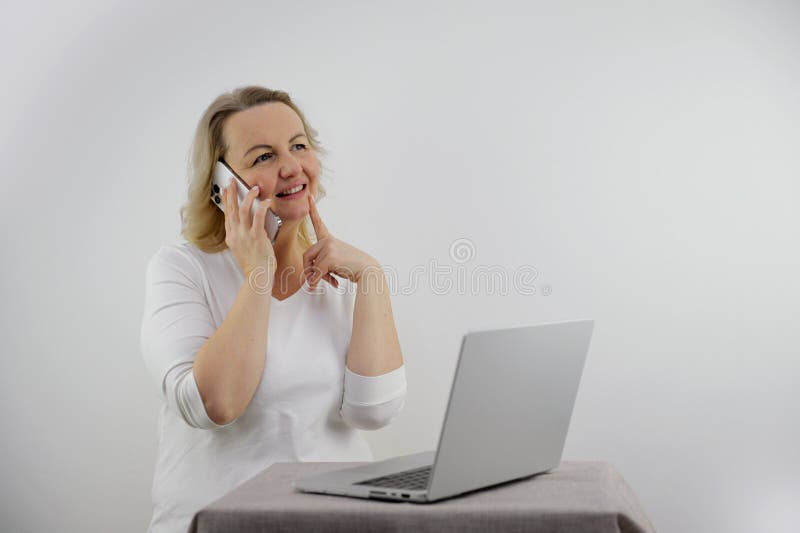 Attractive smiling young business woman using laptop at work desk stock photography