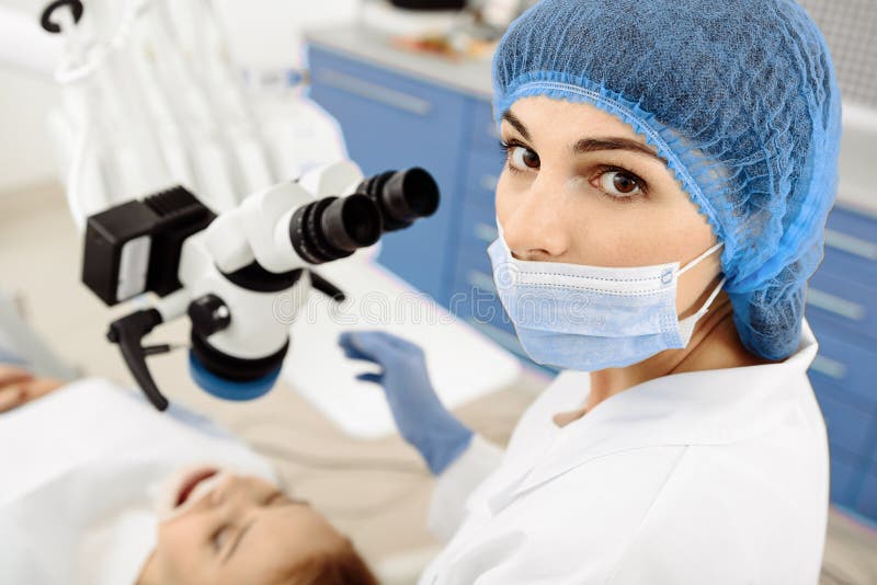 Attractive stomatologist treating her patient