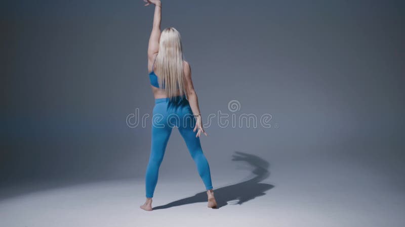 Attractive Talented Blonde Woman Dancing on Blue Background in Studio