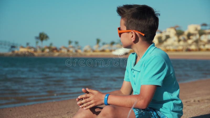 Attractive teenage boy enjoying beautiful coastline in resort beach.
