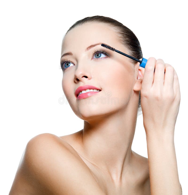 Attractive woman applying mascara on eyelashes