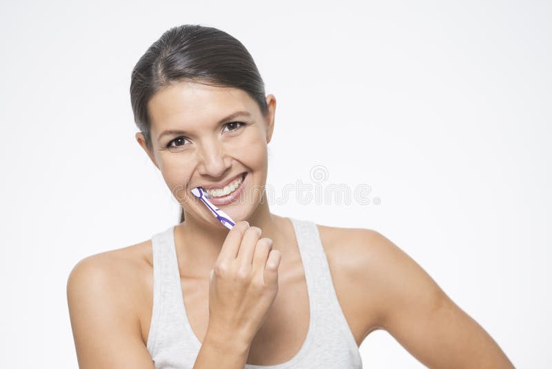 Attractive woman brushing her teeth stock photo Attractive woman brushing her teeth stock photo