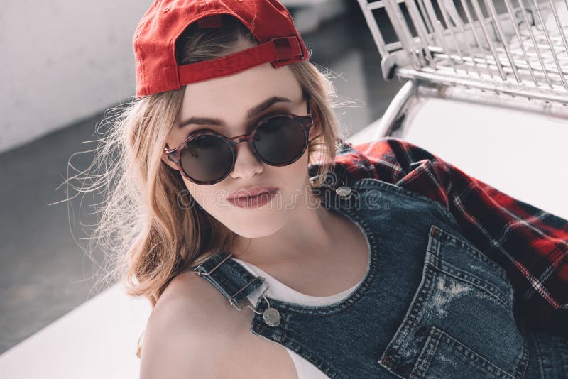 Attractive Woman in Cap and Sunglasses Smiling at Camera Stock Image