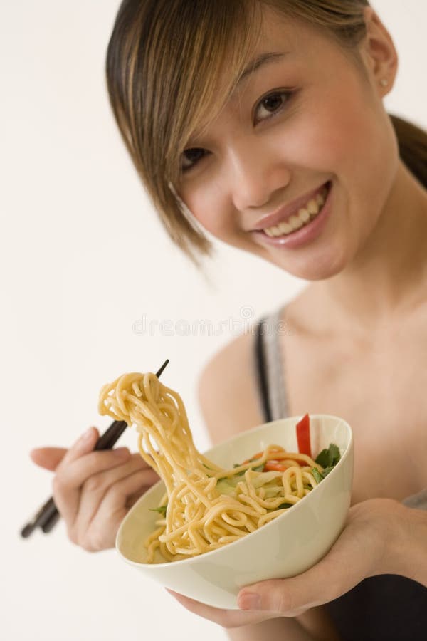 Attractive woman eating noodles