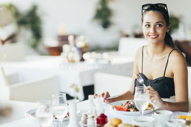 Attractive Woman Eating in Restaurant Stock Image - Image of cute
