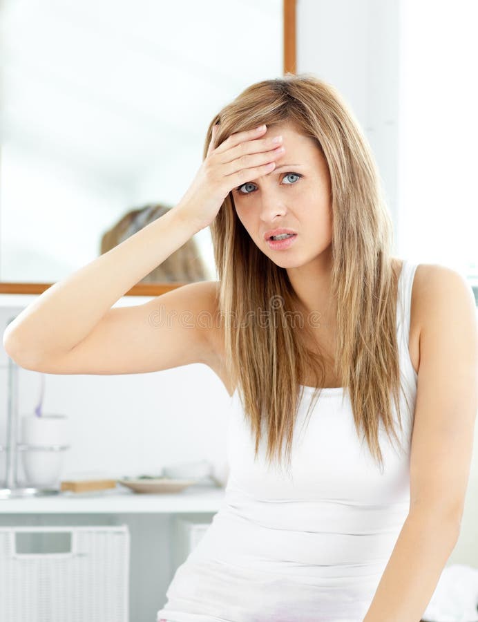 Attractive woman having a headache in the bathroom royalty free stock photos