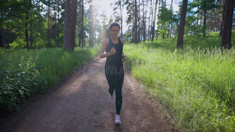 Attractive woman jogging on the trail in the park. Sport and recreation