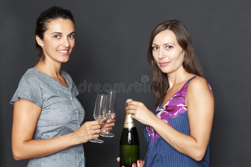 Attractive woman opens a champagne bottle