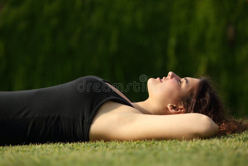 Attractive woman relaxed lying on the grass