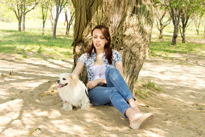 Attractive woman resting in shade with her dog