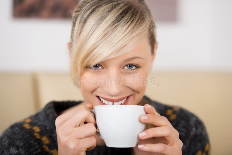 Attractive woman smiling with a cup of coffee royalty free stock photo