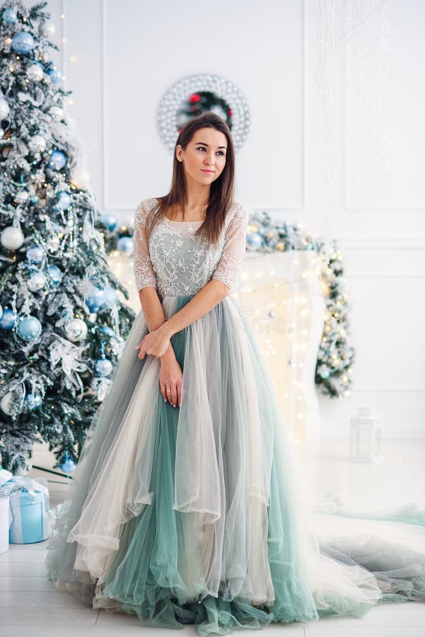 Attractive Woman In Tender Evening Dress Near Christmas Tree 