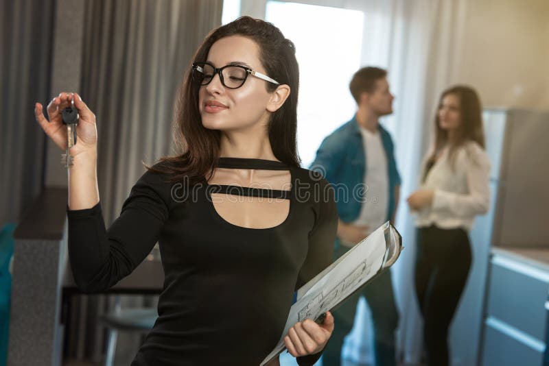 Attractive Woman Realtor Property Manager With Keys In One Hand And Documents In Anither During 