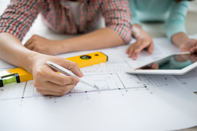 Attractive young asian adult couple looking at house plans.