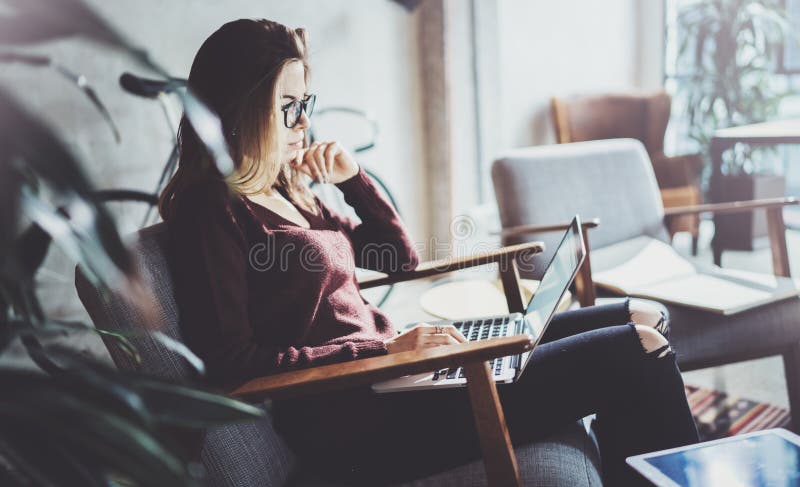 Attractive young businesswoman wearing casual clothes and working at coworking office.Female using contemporary mobile stock photography Attractive young businesswoman wearing casual clothes and working at coworking office.Female using contemporary mobile stock photography