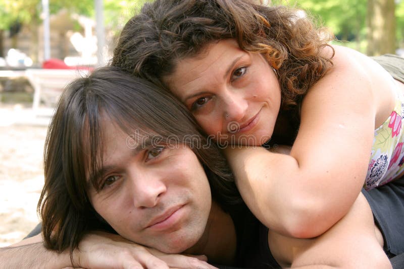 Attractive young couple, she lying on top of him in relaxed pose
