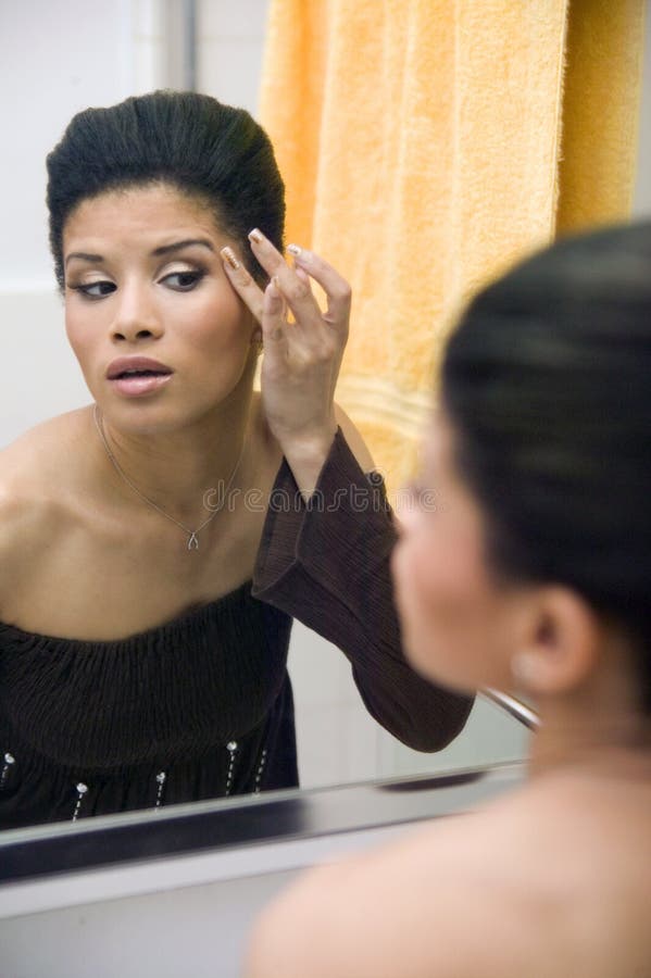 Attractive young ethnic girl applying make up royalty free stock images Attractive young ethnic girl applying make up royalty free stock images