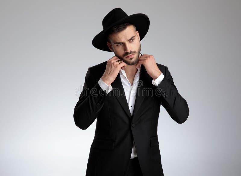 Attractive young fashion model fixing collar on grey background royalty free stock photo Attractive young fashion model fixing collar on grey background royalty free stock photo