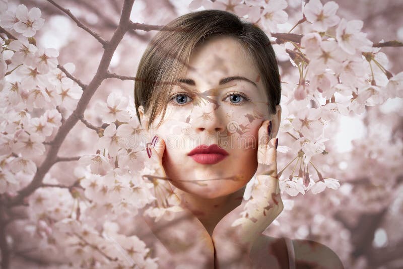 Attractive young girl with blue eyes on background of pink sakura flowers, natural cosmetics concept stock photo Attractive young girl with blue eyes on background of pink sakura flowers, natural cosmetics concept stock photo