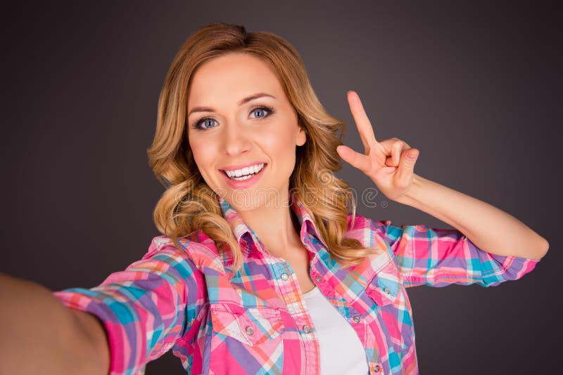 Attractive Young Girl Making Selfie And Gesturing With Two Fingers