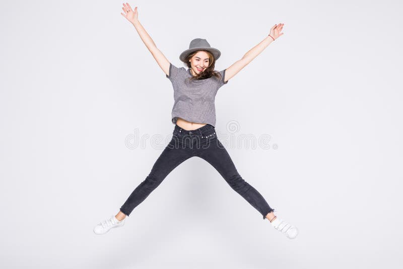 Attractive beautiful young girl wearing casual flying in air isolated over grey background stock image Attractive beautiful young girl wearing casual flying in air isolated over grey background stock image