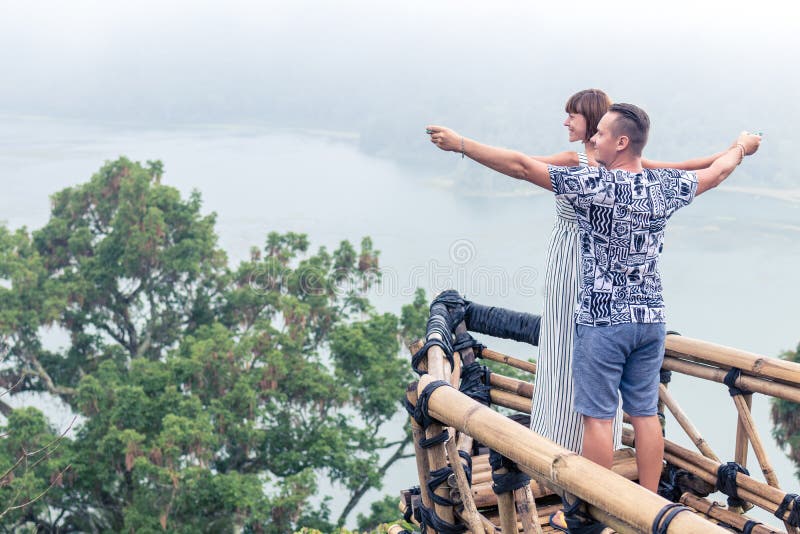 Attractive young loving romantic couple on the tropical fog landscape of Bali island, Indonesia.