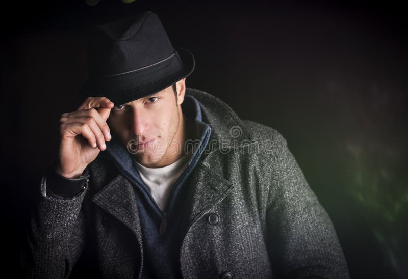 Attractive Young Man at Night, Wearing Winter Coat and Fedora Hat Stock