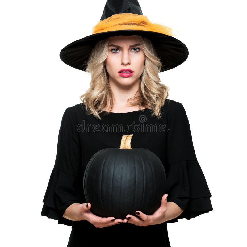 Attractive young woman in Halloween Witch costume holding large black pumpkin, looking confused. Halloween concept. royalty free stock photo Attractive young woman in Halloween Witch costume holding large black pumpkin, looking confused. Halloween concept. royalty free stock photo