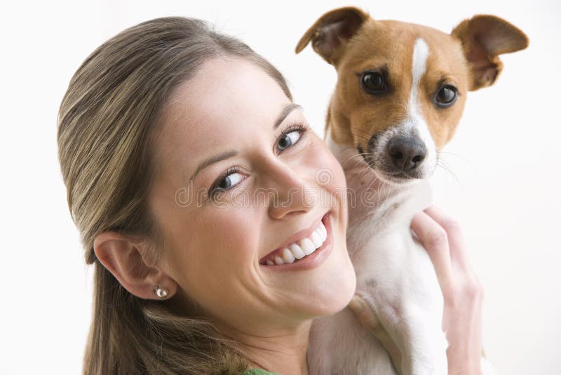 Attractive Young Woman Holding A Dog And Smiling