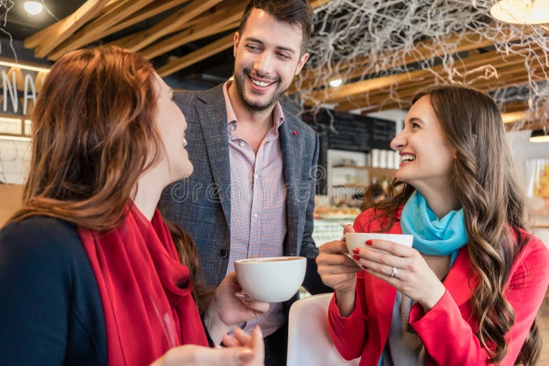Attractive young woman meeting an old friend while enjoying a hot drink stock photography Attractive young woman meeting an old friend while enjoying a hot drink stock photography