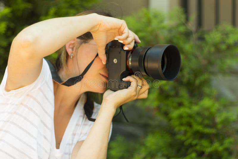 Attractive young woman photographer taking photos with dslr camera outdoors. Copy space stock images Attractive young woman photographer taking photos with dslr camera outdoors. Copy space stock images