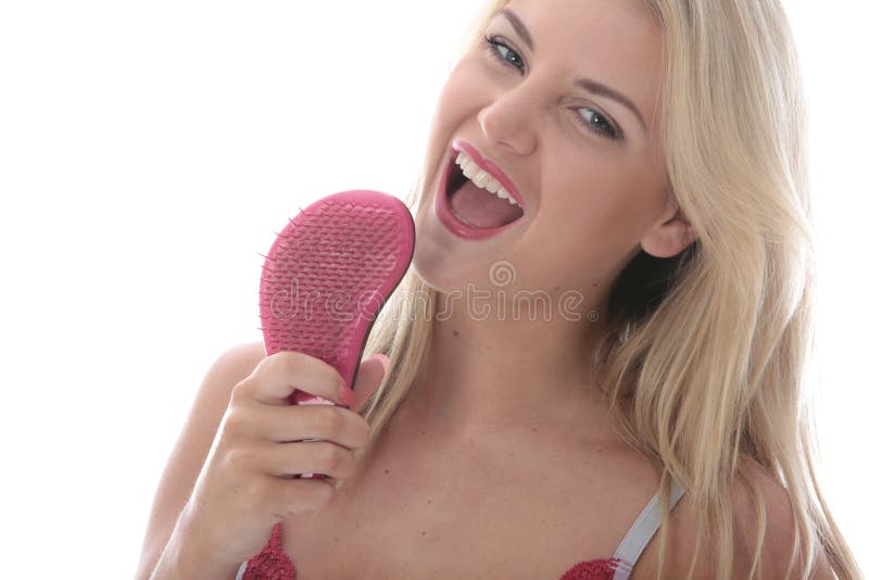 Model Released. Attractive Young Woman Singing into a Hairbrush