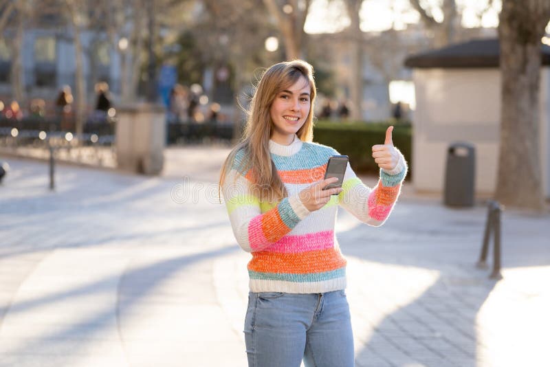 Attractive young woman on smart phone checking social media mobile apps outside city stock photo Attractive young woman on smart phone checking social media mobile apps outside city stock photo