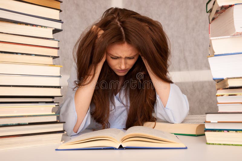 Attractive young woman student undre stress while studiing for e