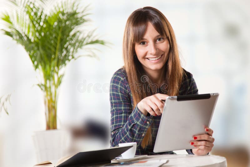 Attractive young woman with a tablet in the office stock images