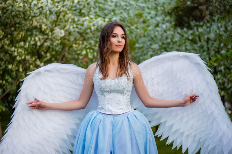 Woman in a White Corset and a Blue Puffy Dress with Large White Angel ...
