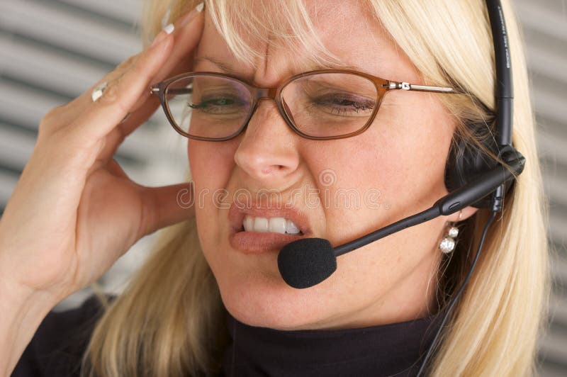 Attractive businesswoman gets headache while she talks on her phone headset. Attractive businesswoman gets headache while she talks on her phone headset