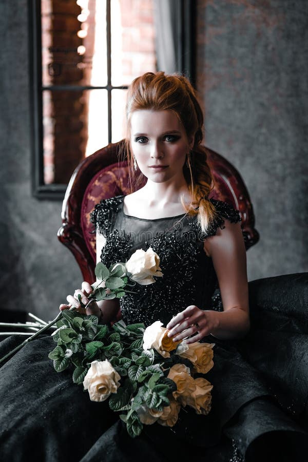 Attraktiv kvinna i svart kl?nning i medeltida inre royaltyfri bild Attraktiv kvinna i svart kl?nning i medeltida inre royaltyfri bild