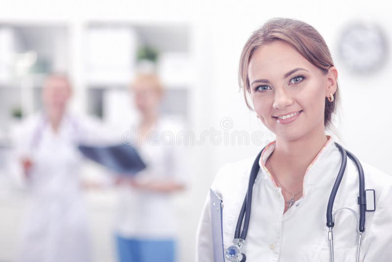 Attraktiv kvinnlig doktor framme av den medicinska gruppen royaltyfri fotografi Attraktiv kvinnlig doktor framme av den medicinska gruppen royaltyfri fotografi