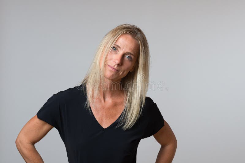 Attraktiv lycklig blond kvinna med ett tyst leende arkivfoto Attraktiv lycklig blond kvinna med ett tyst leende arkivfoto