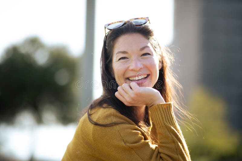 Attraktiv ung asiatisk kvinna som sitter utanför staden arkivbild
