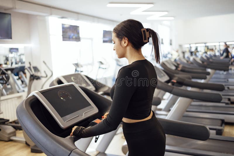 Attraktiv ung idrottslig kvinna som tränar på gymmet