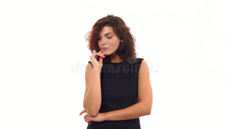 Attraktiv ung kvinna som flörtar och trycker på hennes hår som isoleras på en vit bakgrund