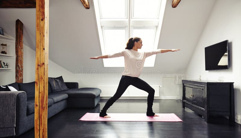 Attraktiv ung kvinna som hemma gör yoga arkivfoto Attraktiv ung kvinna som hemma gör yoga arkivfoto